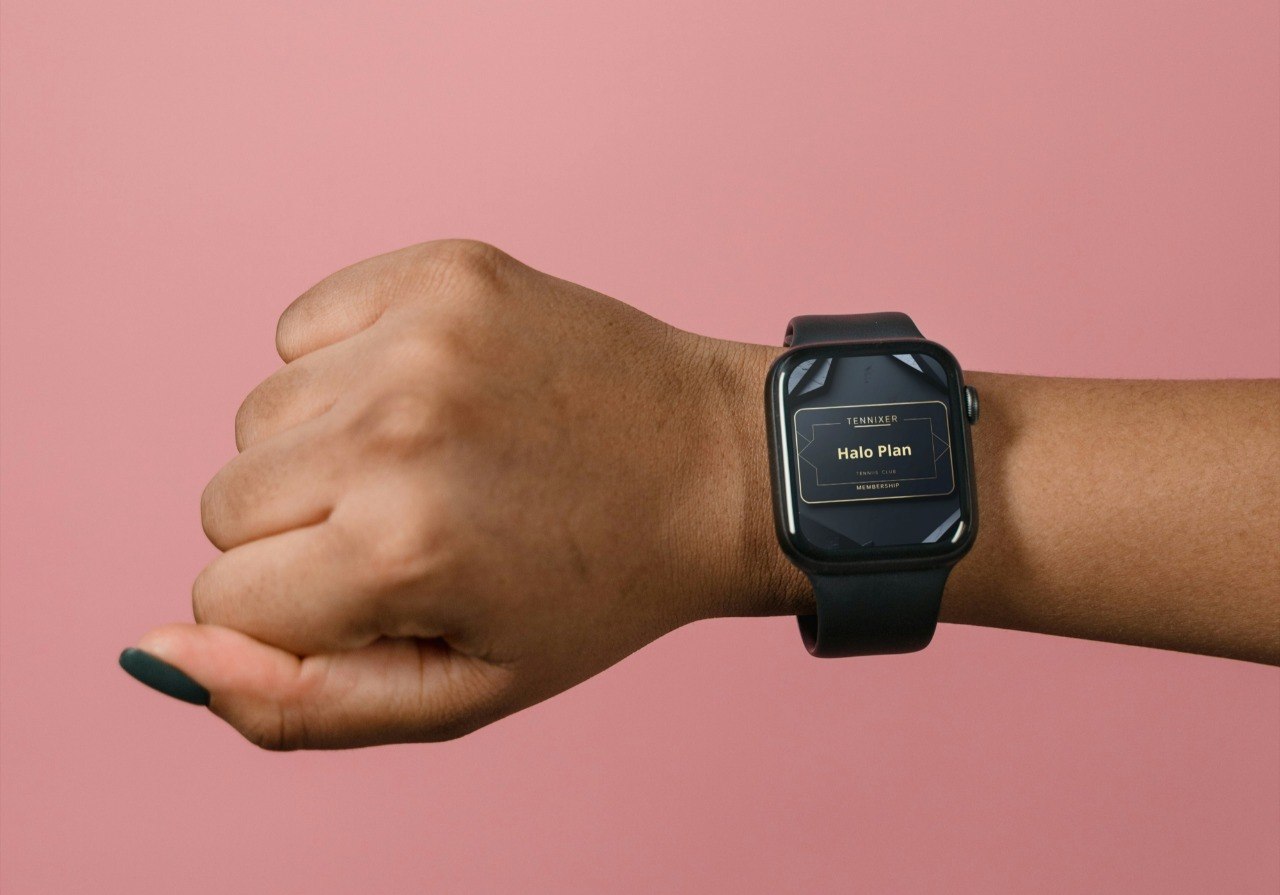 Person wearing a smartwatch on a pink background