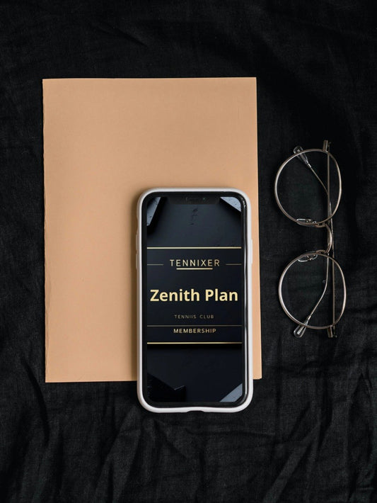 Phone displaying 'Tennixer Zenith Plan' on a black surface with a notebook and glasses.